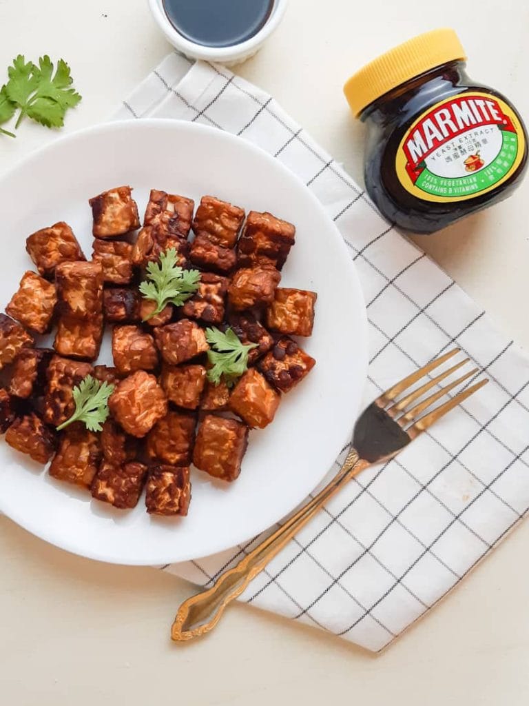 Tempeh served on a plate with a fork beside it.