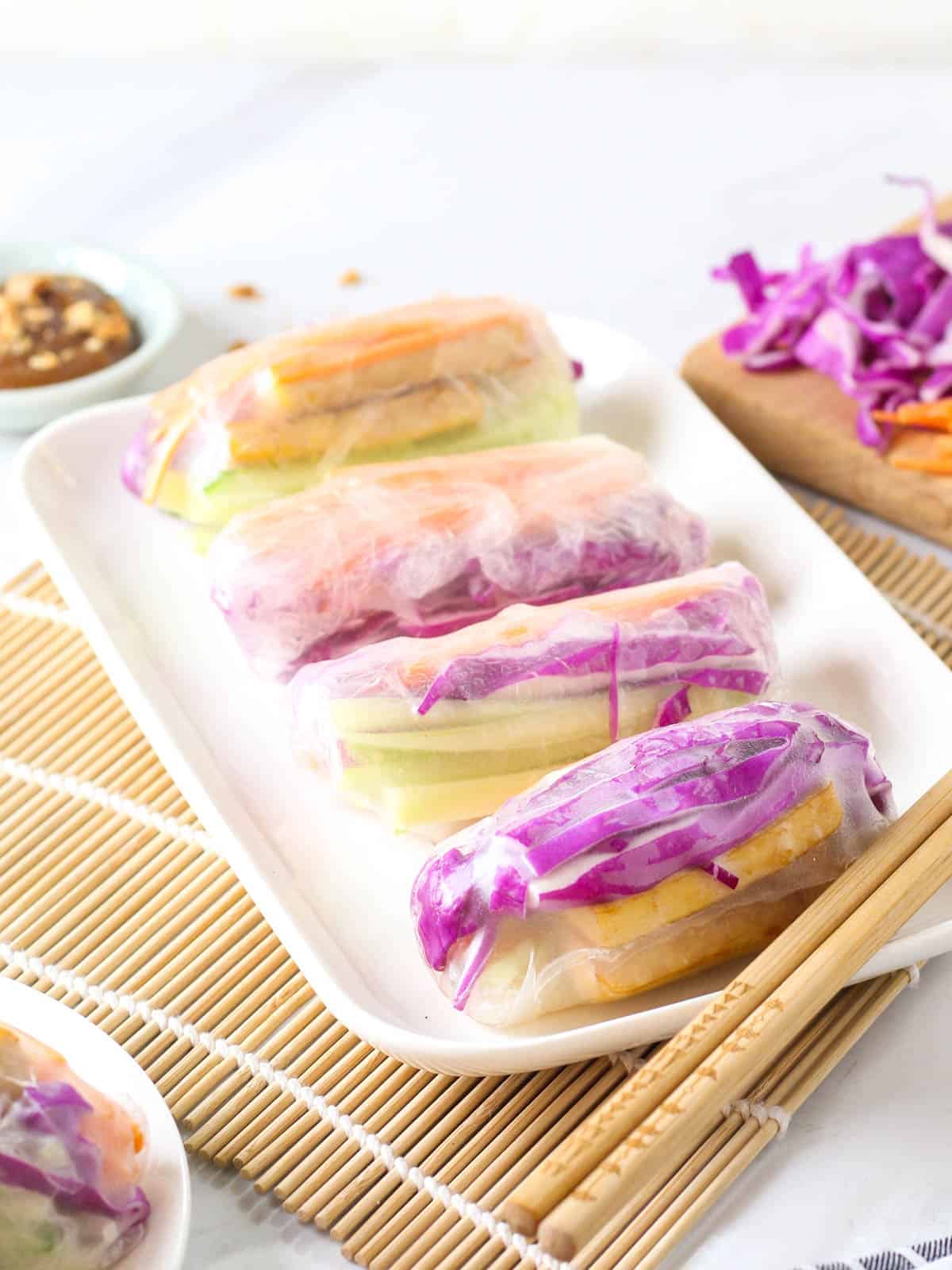 A close up look of goi cuon choy served on a rectangular plate with a pair of chopsticks at the side.