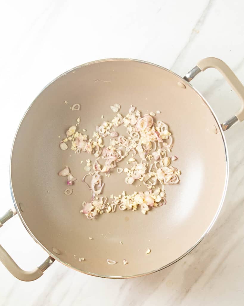 Cooking shallots and garlic in a wok.
