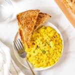 Soft tofu scramble served with toast with a fork in a plate.