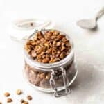 An opened jar of lentils with a teaspoon in the background.