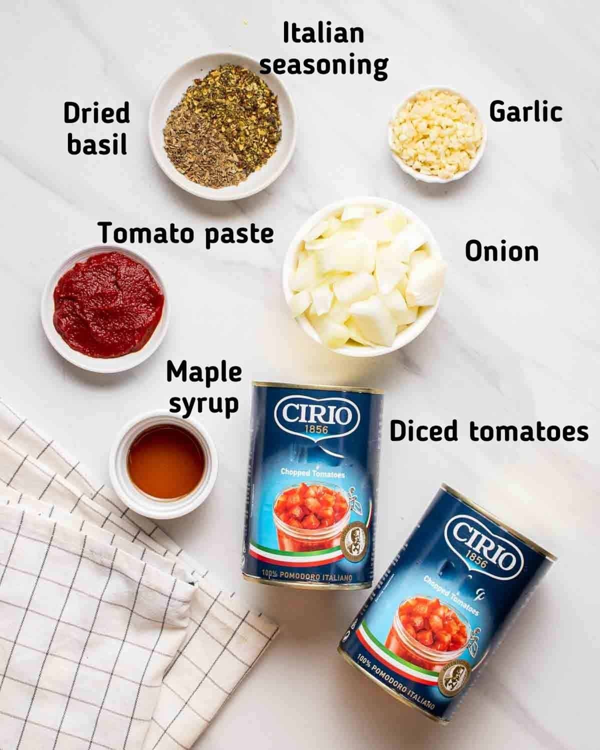 Ingredients needed like tomatoes, onion, garlic, tomato paste, herbs and seasonings on a white background.