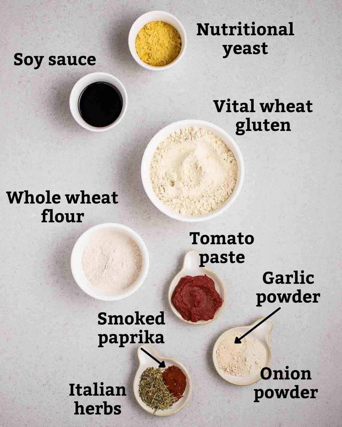 Ingredients needed like vital wheat gluten, whole wheat flour and seasonings on a grey background.
