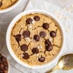 Baked oats topped with sea salt flakes with chocolate chips and a spoon beside.