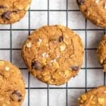 A few protein cookies on a black cooling tray topped with sea salt flakes.