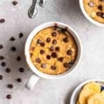 Banana oats mug cake with chocolate chips and dish of sliced bananas beside.