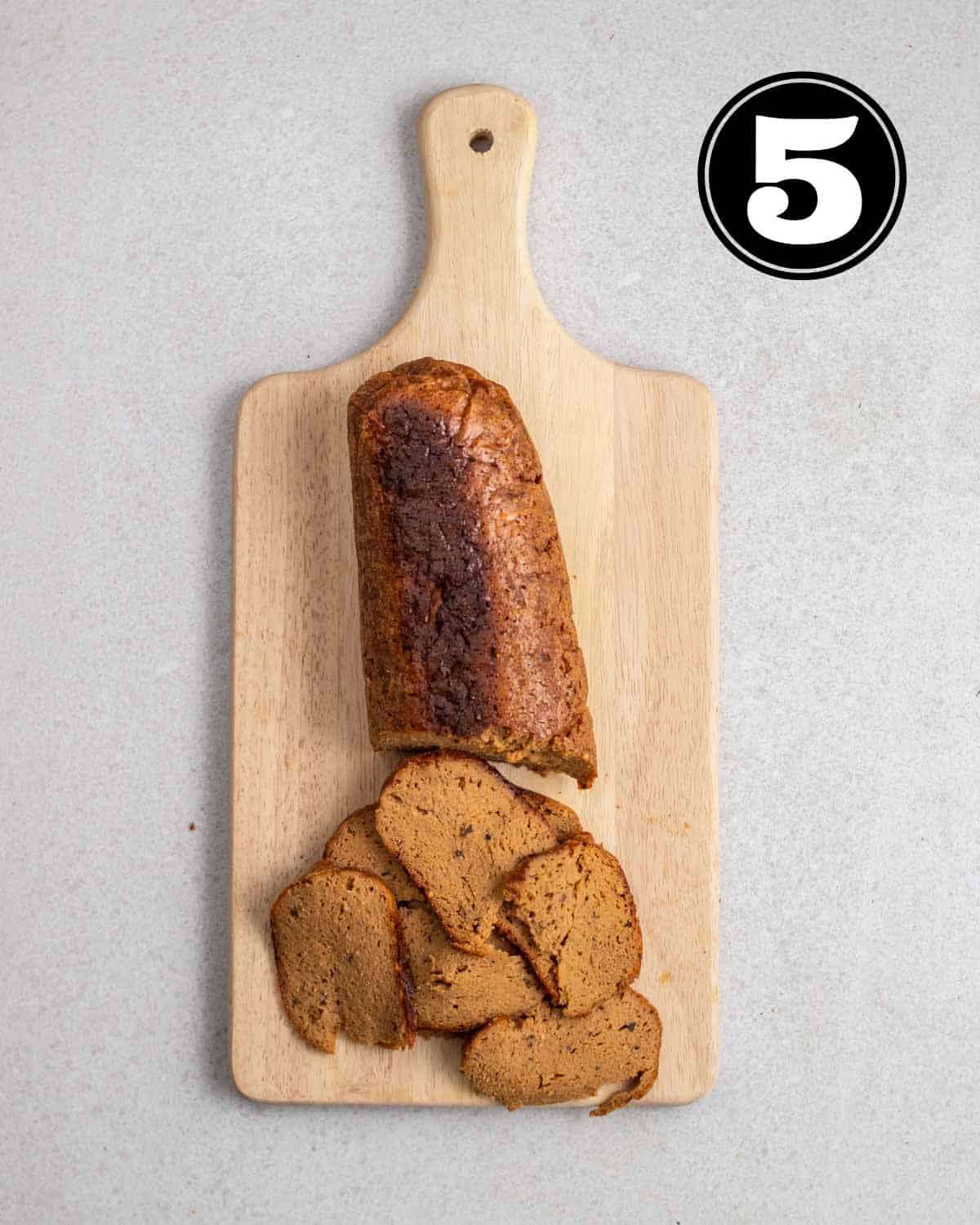Partially shaved seitan log on a wooden board.