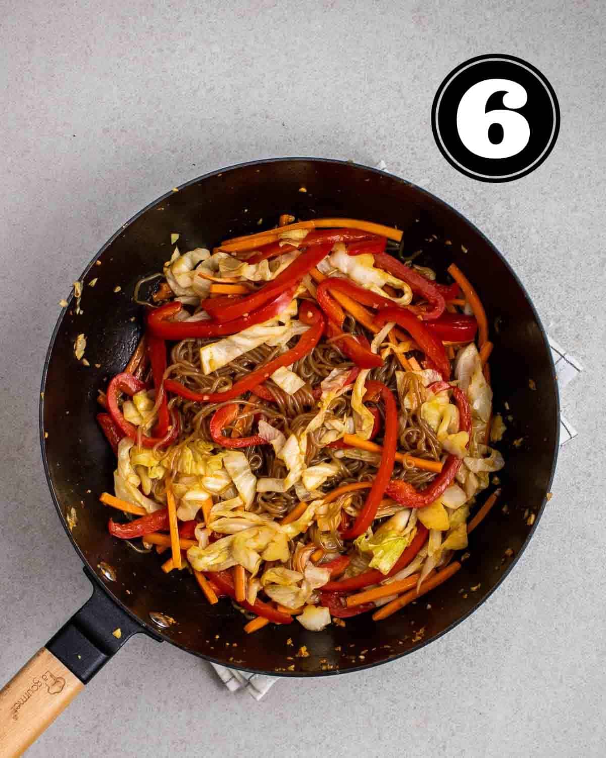 A pan of shirataki noodles stir-fry in a wok.