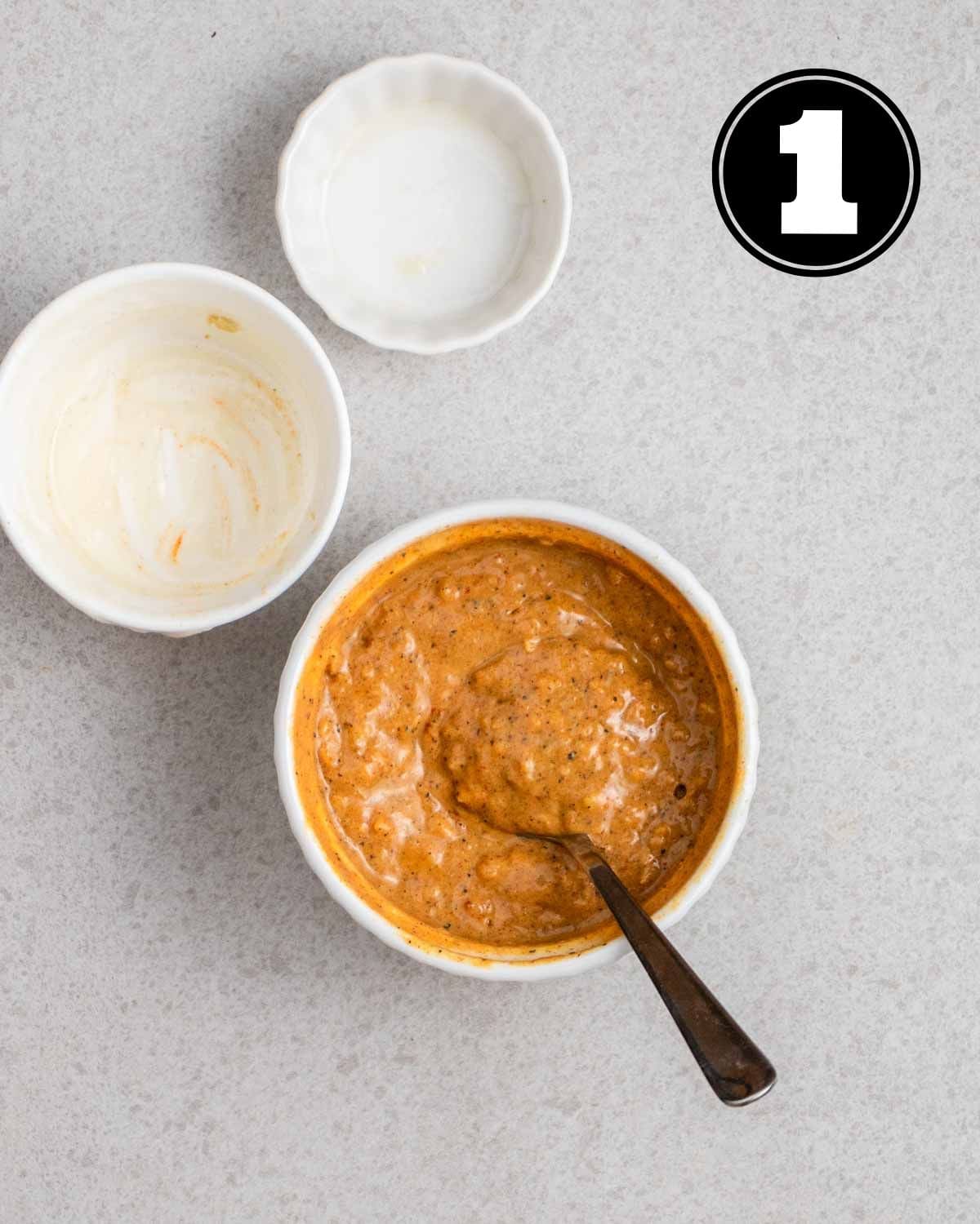 Marinade for tandoori tofu in a ramekin with a teaspoon beside.