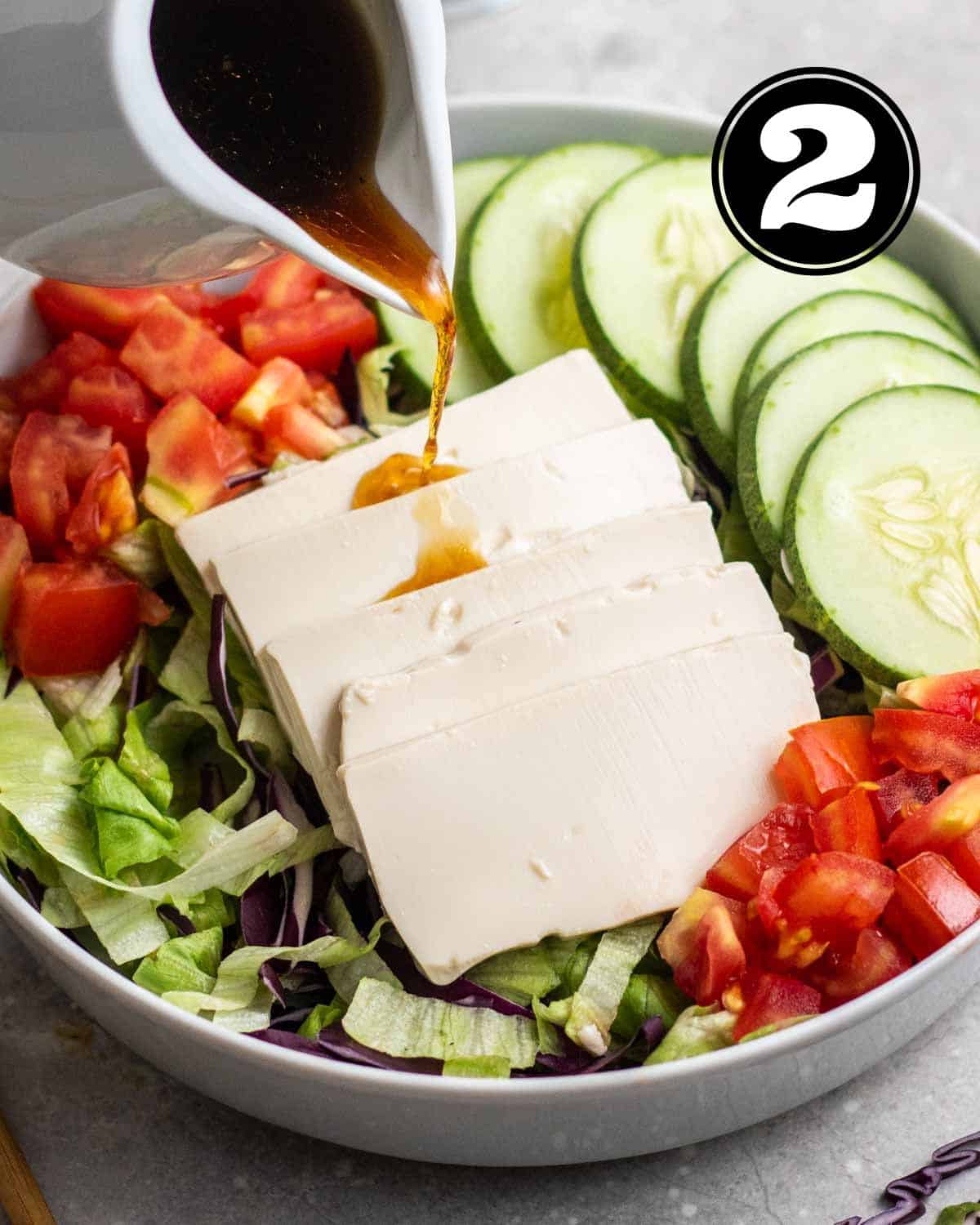 Pouring sesame soy dressing over Japanese salad.