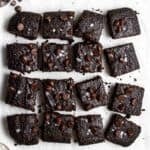 A tray of sliced oat flour brownies arranged on a parchment paper.