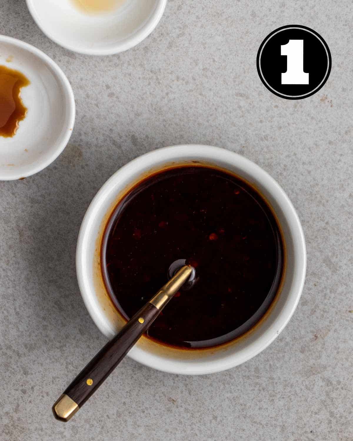Stir-fry sauce in a ramekin with a teaspoon and 2 sauce dishes beside.