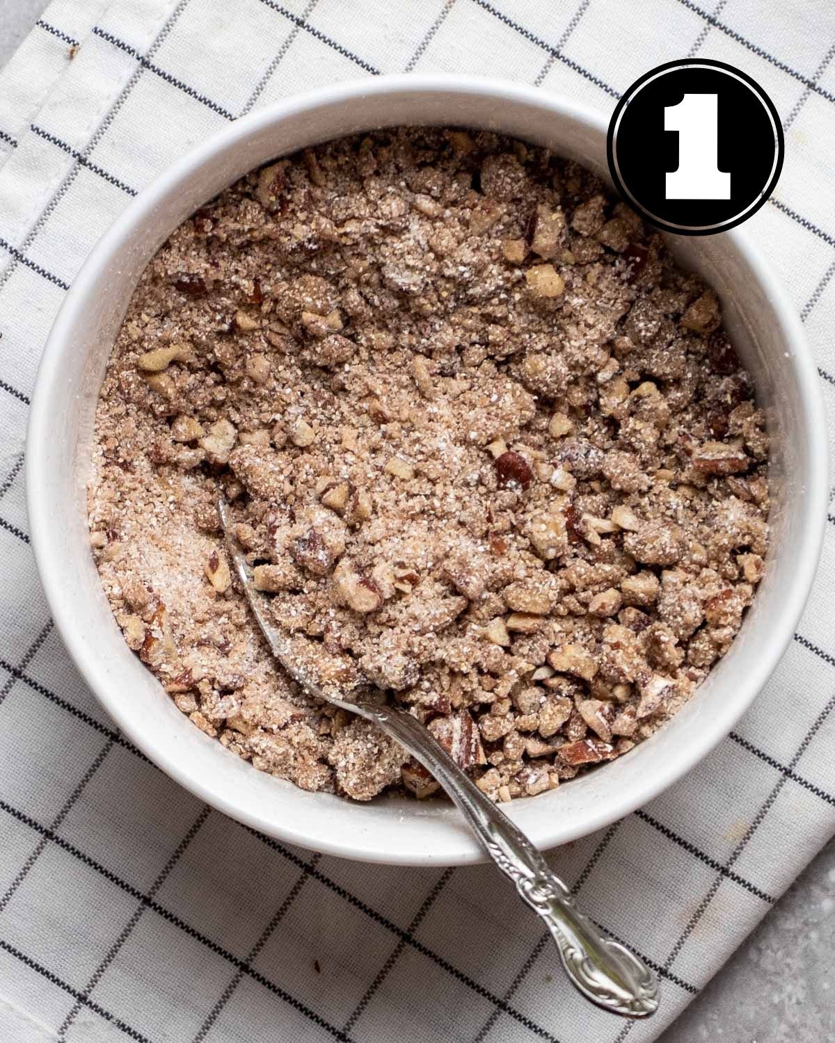 Streusel for coffee cake in a ramekin with a teaspoon beside.