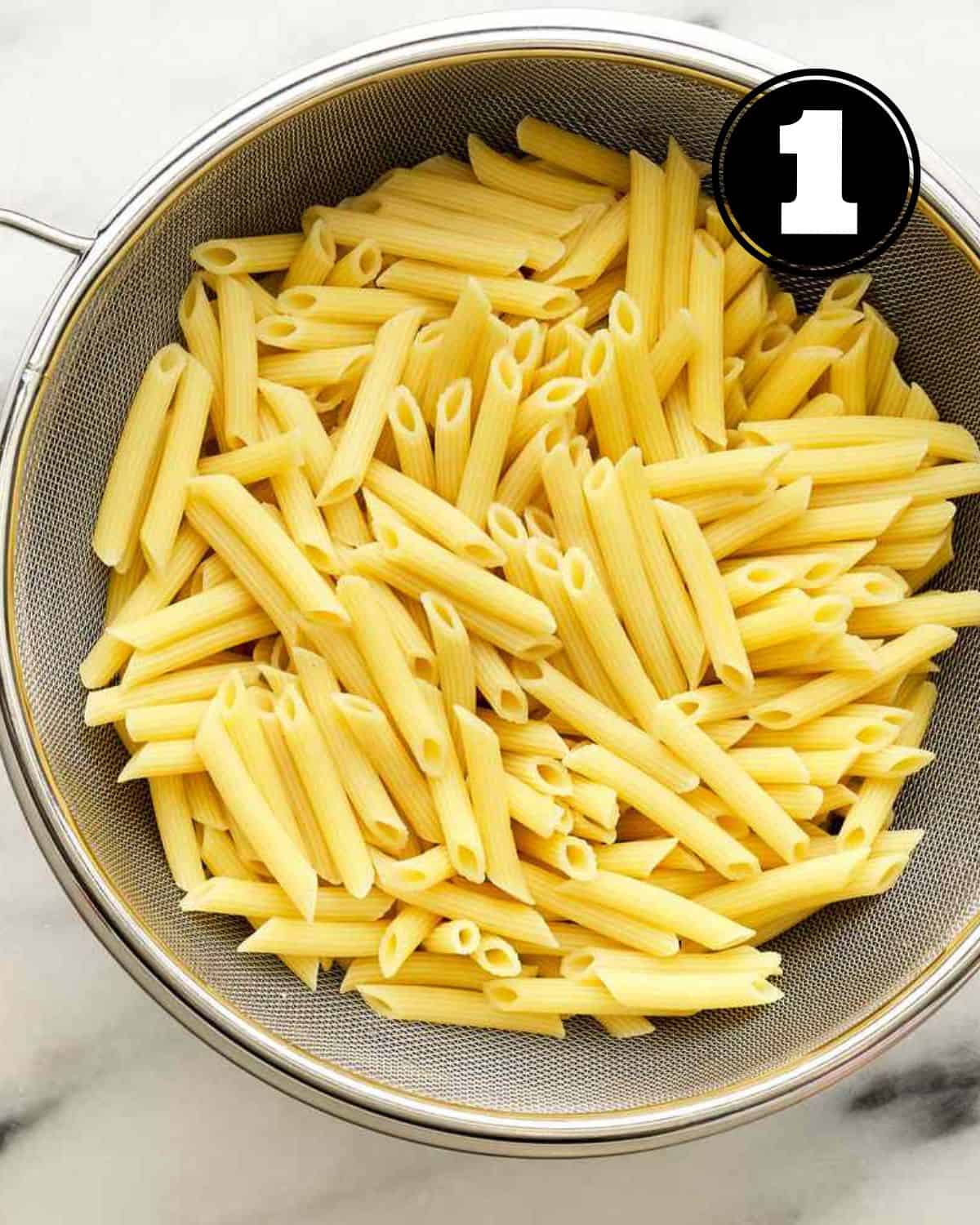 Cooked pasta in a colander. 