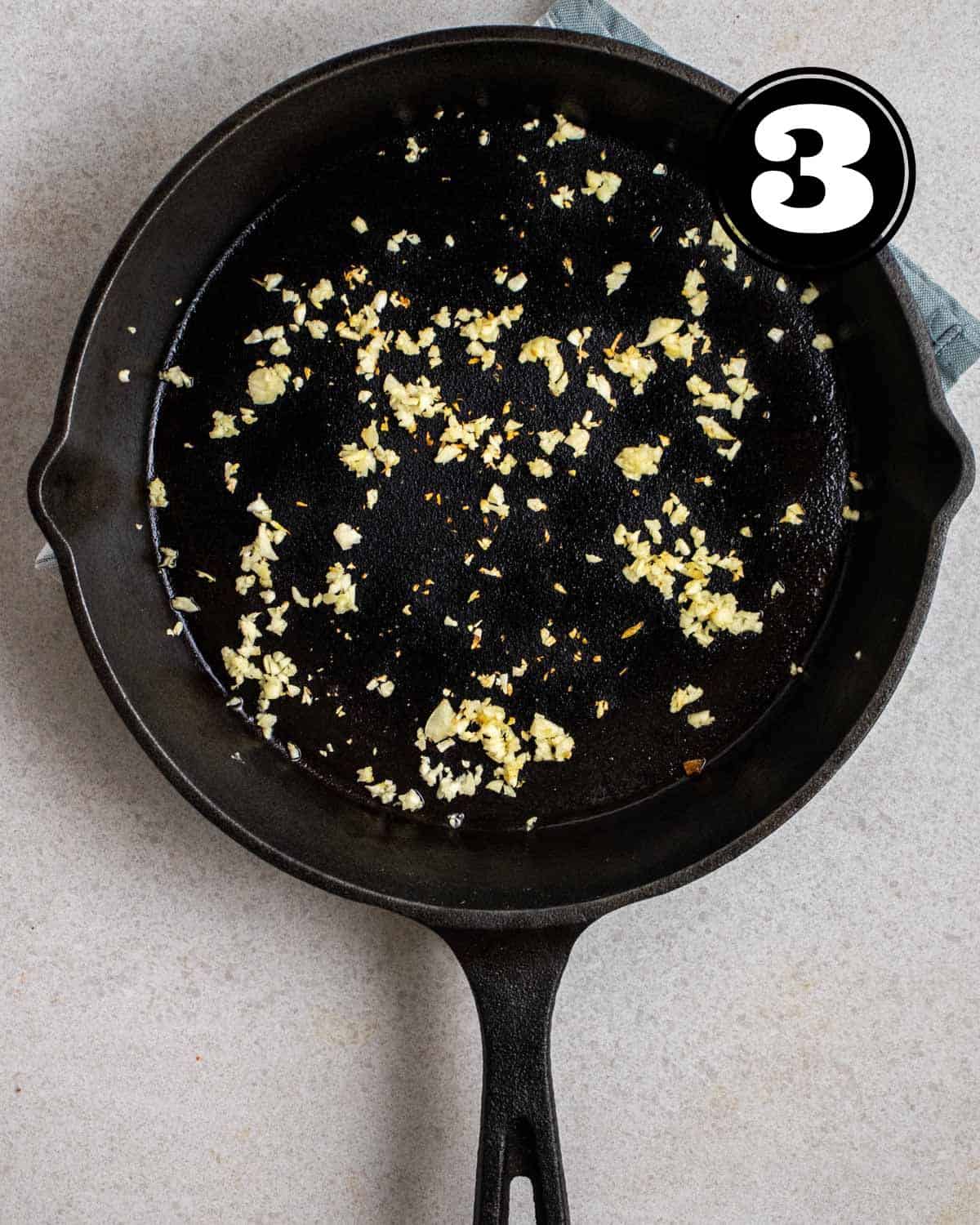 Sauteing garlic in a cast iron skillet.