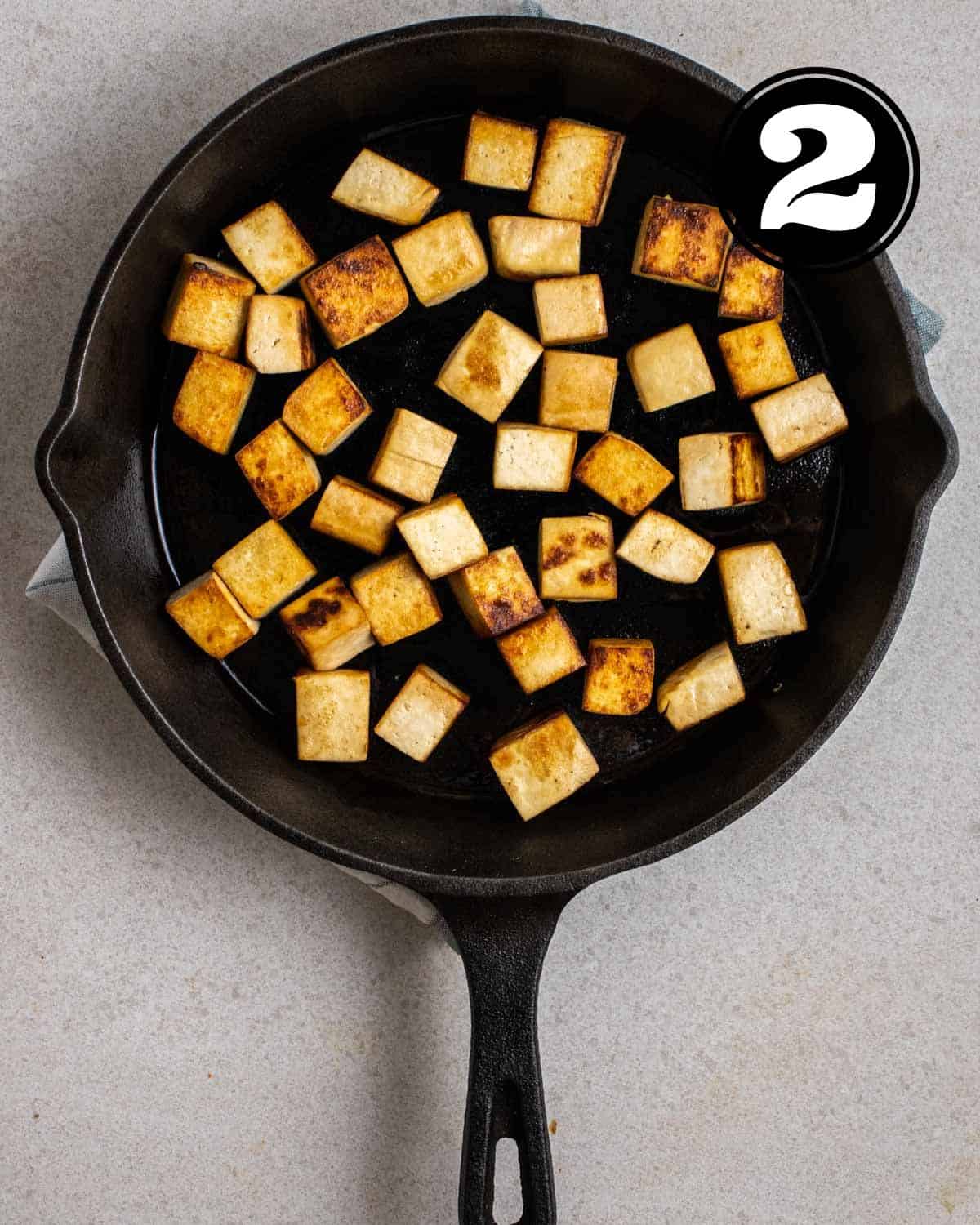 Pan-fried tofu in a cast iron skillet.
