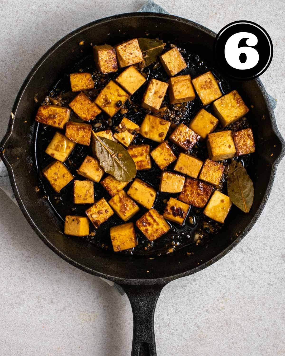 Cooked adobo tofu in a cast iron skillet.