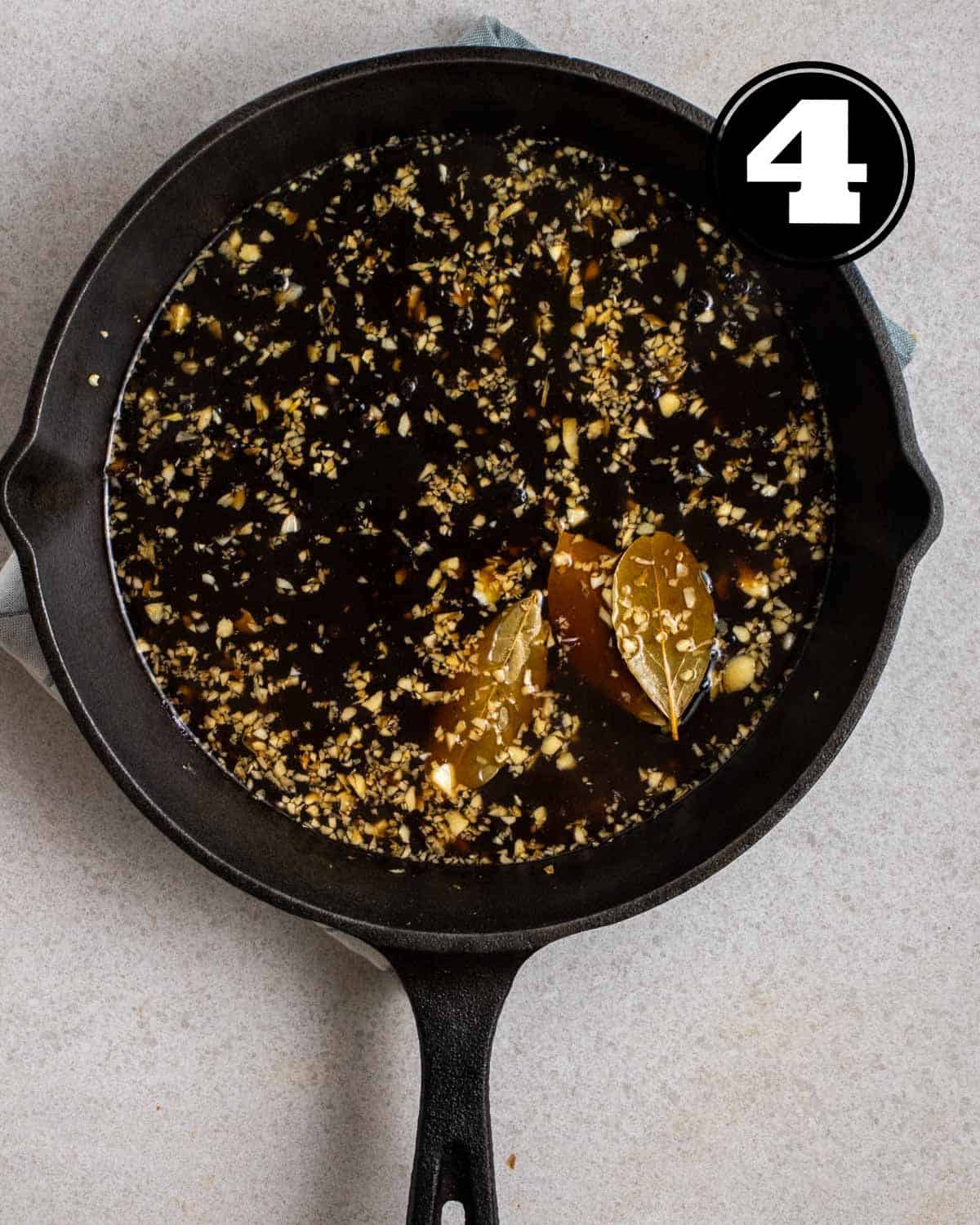 Simmering adobo sauce in a cast iron skillet.