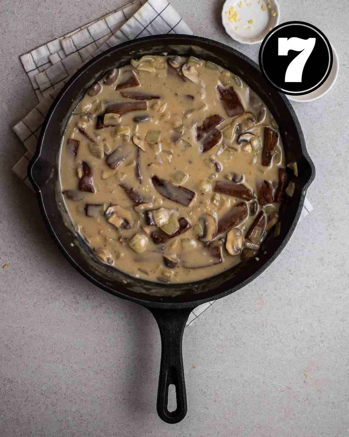 A pan of vegan stroganoff on a white folded teacloth.