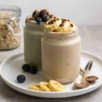 2 jars of overnight oats on a plate with a jar of oats in the background.