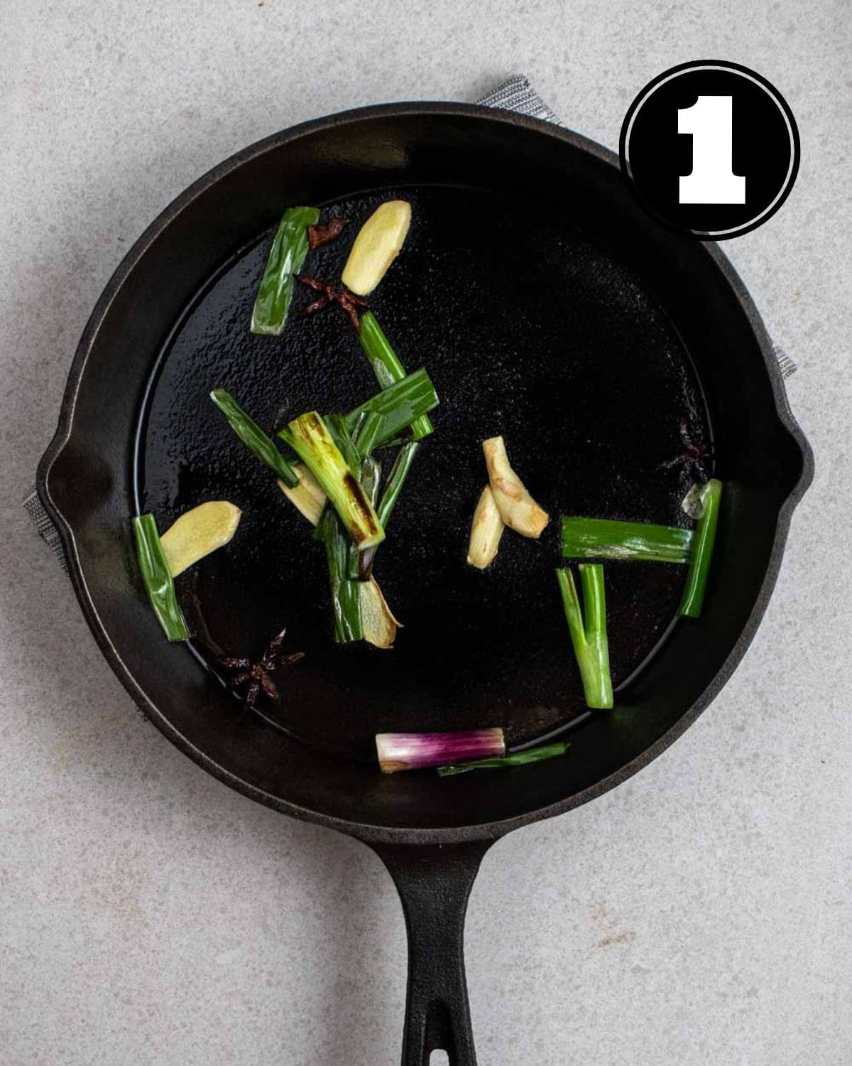 Cooked green onion and ginger in a cast iron pan.