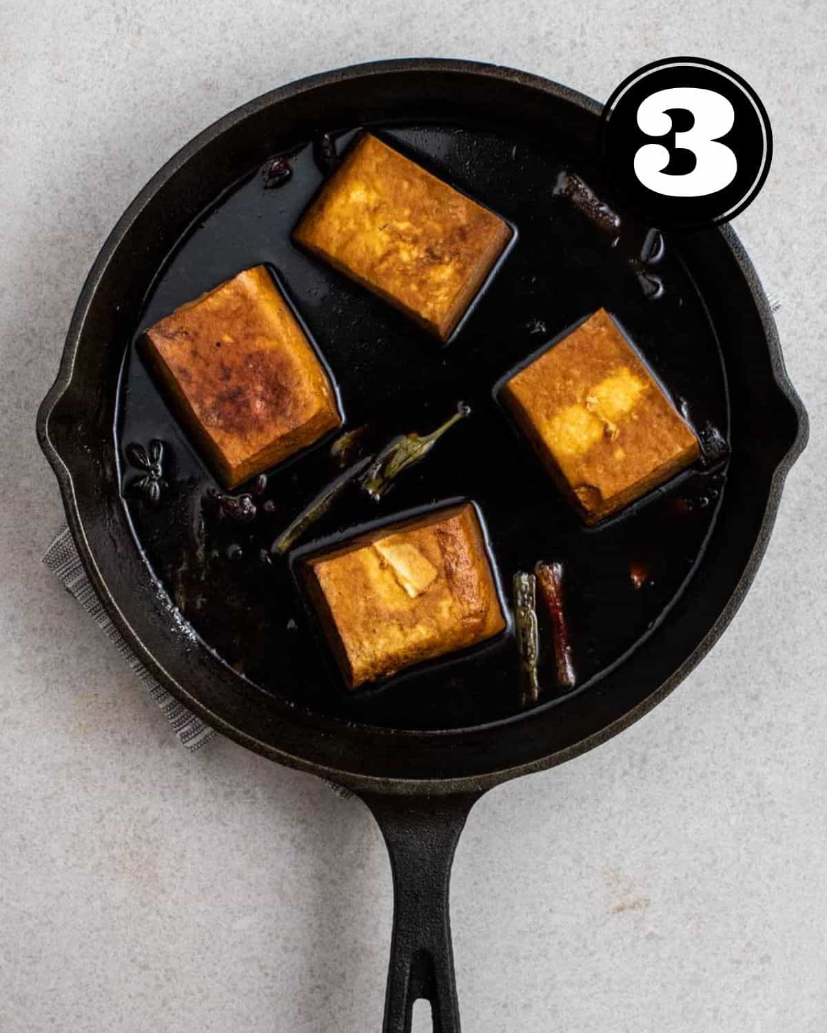 Soy sauce tofu in a cast iron pan.