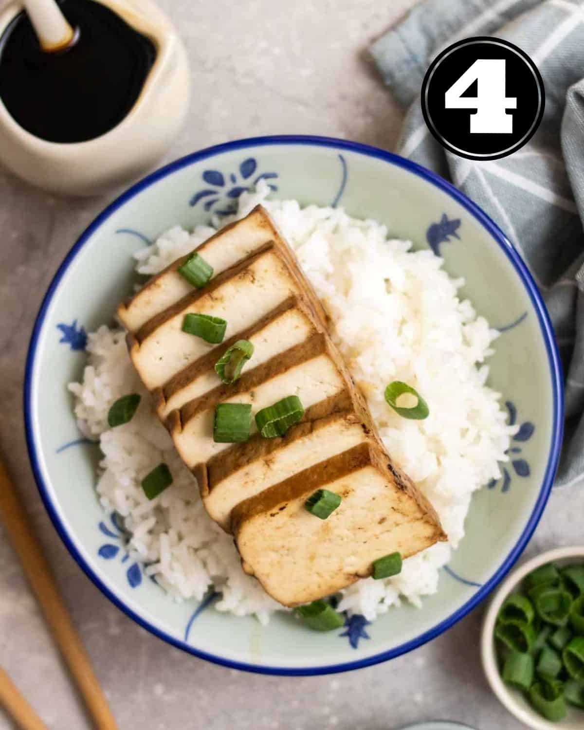 Serving sliced soy sauce tofu on a bowl of rice.