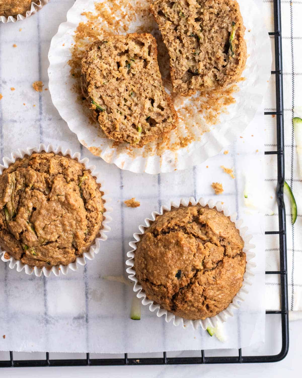 Applesauce zucchini muffins arranged on a black baking tray lined with parchment paper.