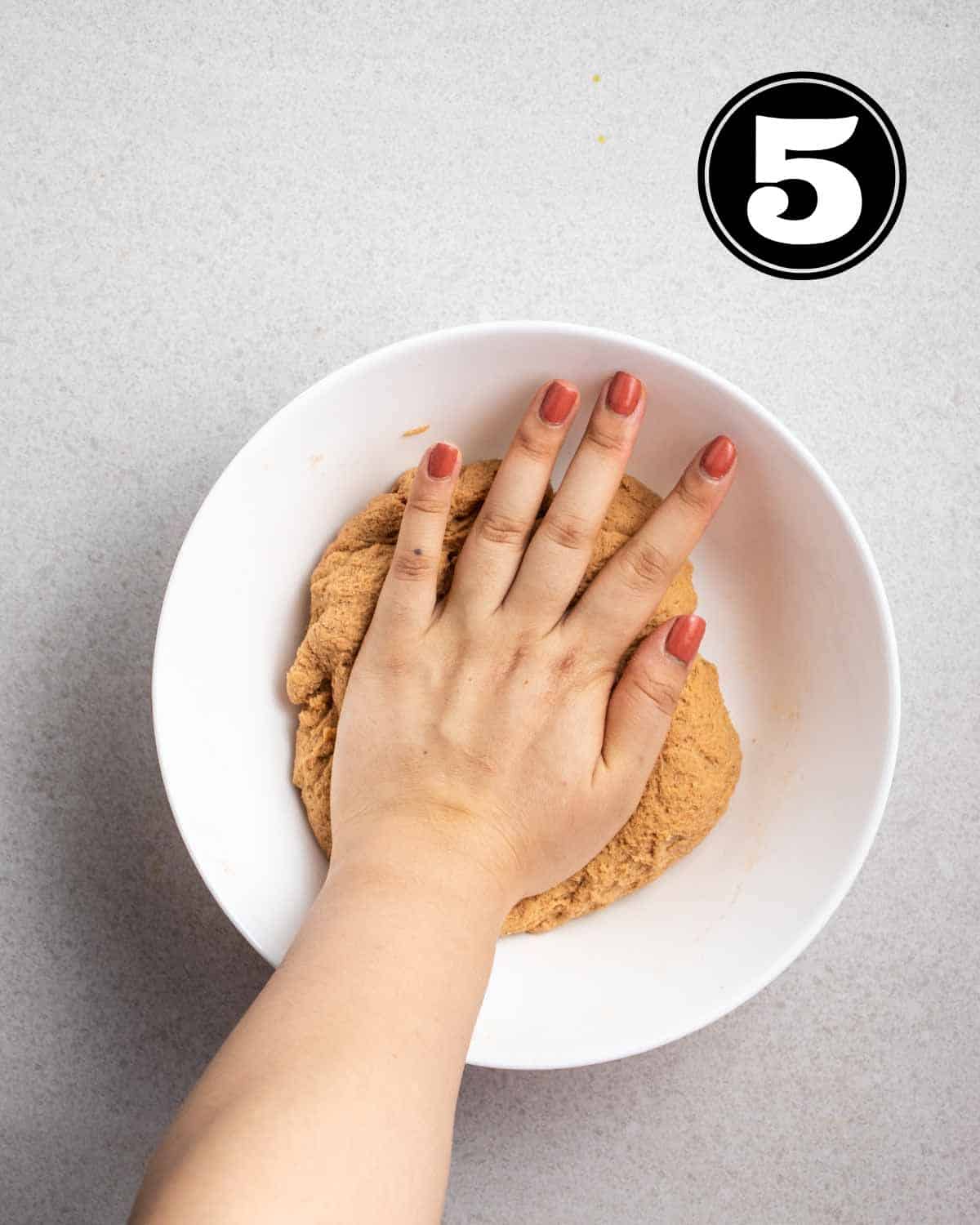 Kneading seitan dough in a white bowl.