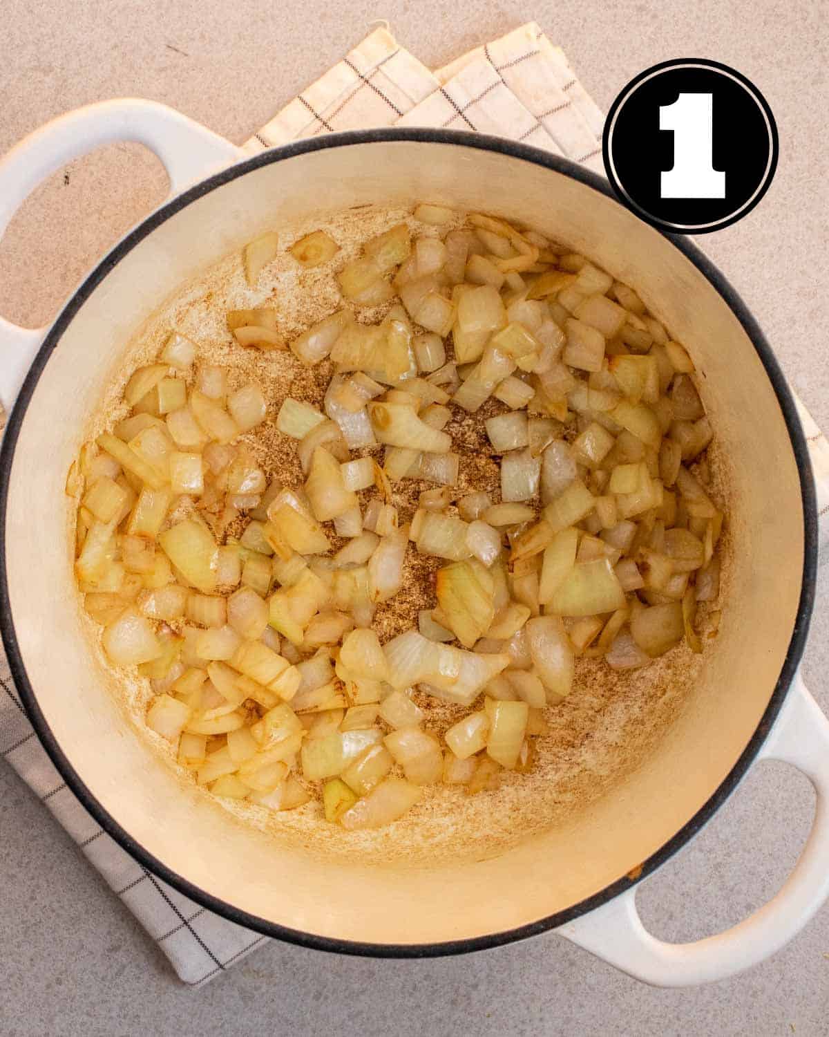 Cooked onion in a white Dutch oven.