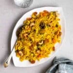Plate of biryani served with spoon.