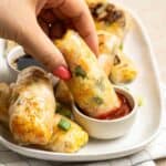 Dipping a piece of rice paper egg rolls in ketchup.