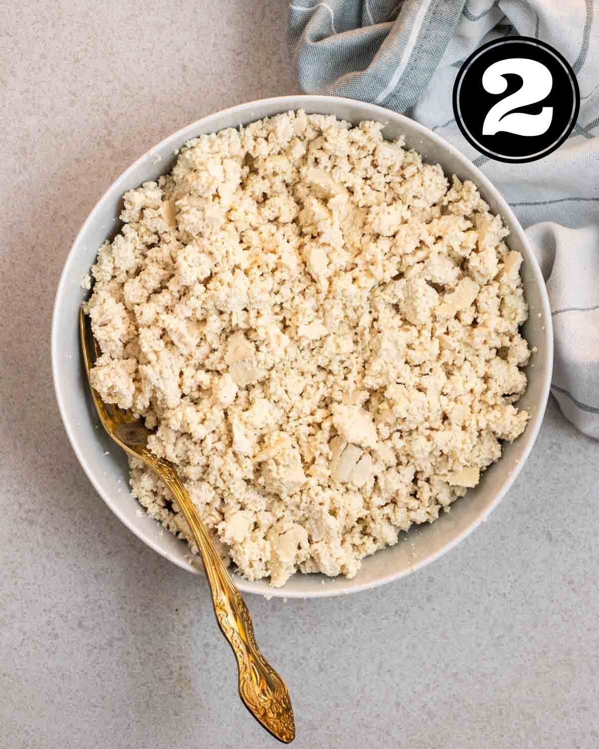 Crumbled tofu in a plate with a fork beside. 