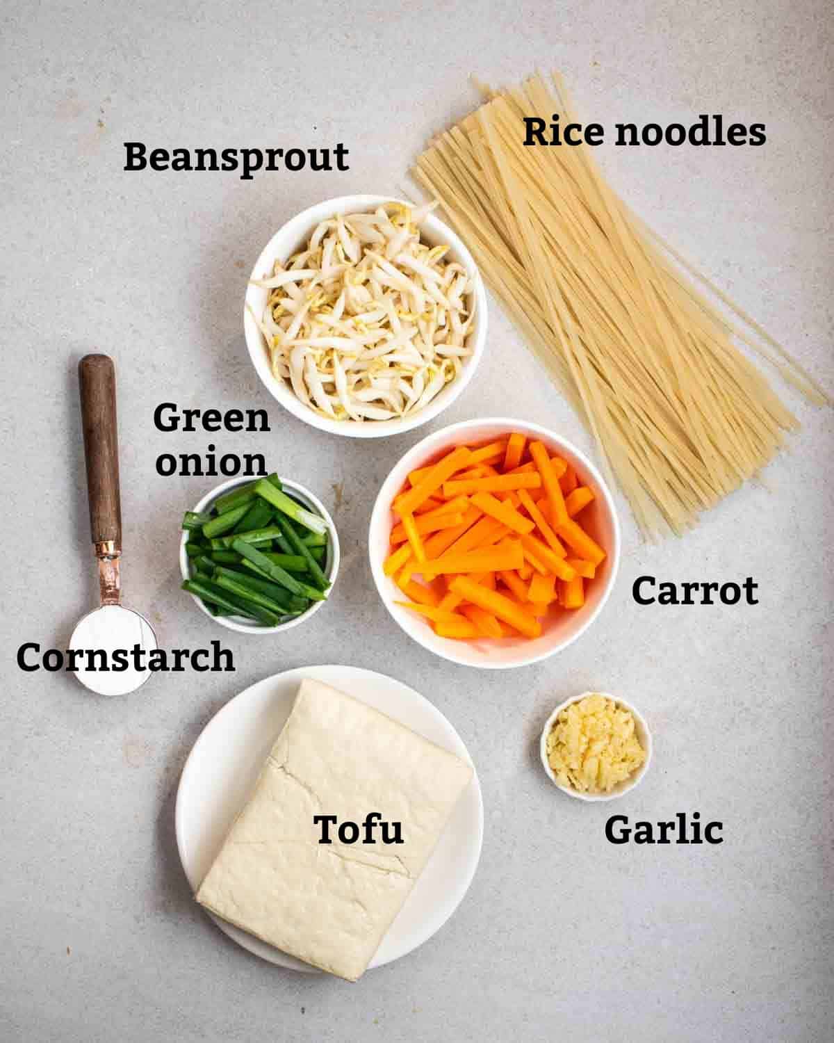 Ingredients needed like rice noodles, tofu, garlic, cornstarch, bean sprouts, carrot, and green onion.