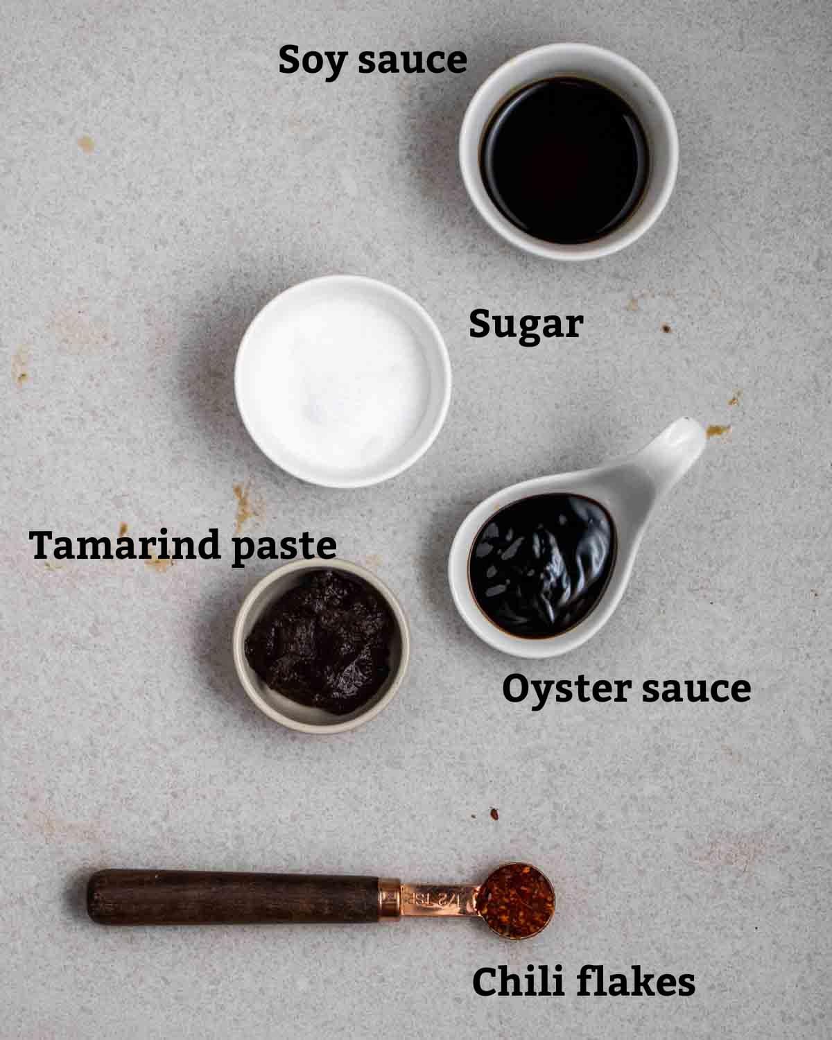 Seasonings needed like soy sauce, sugar, oyster sauce, tamarind paste, and chili flakes.