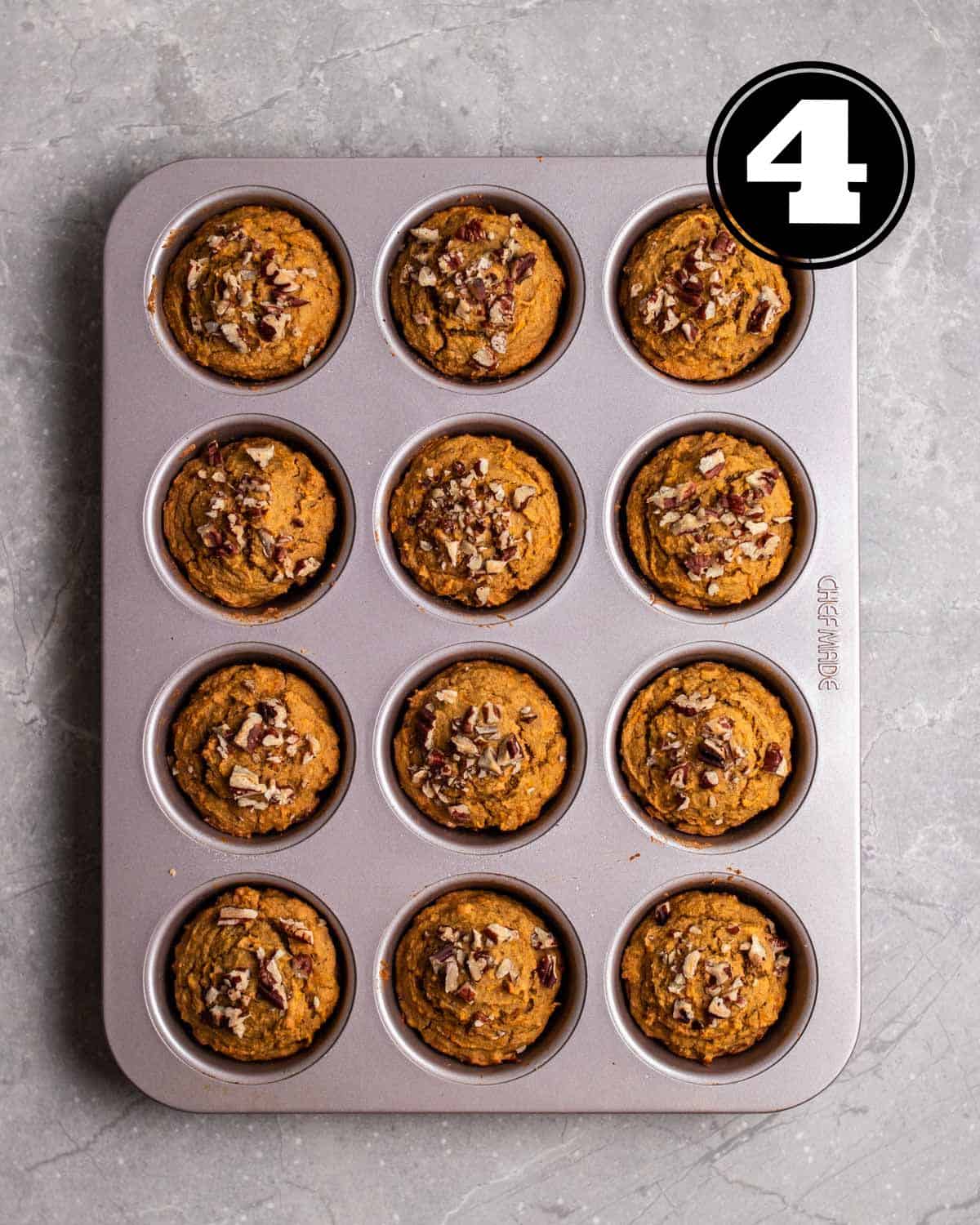 Baked applesauce muffins in a muffin tin.