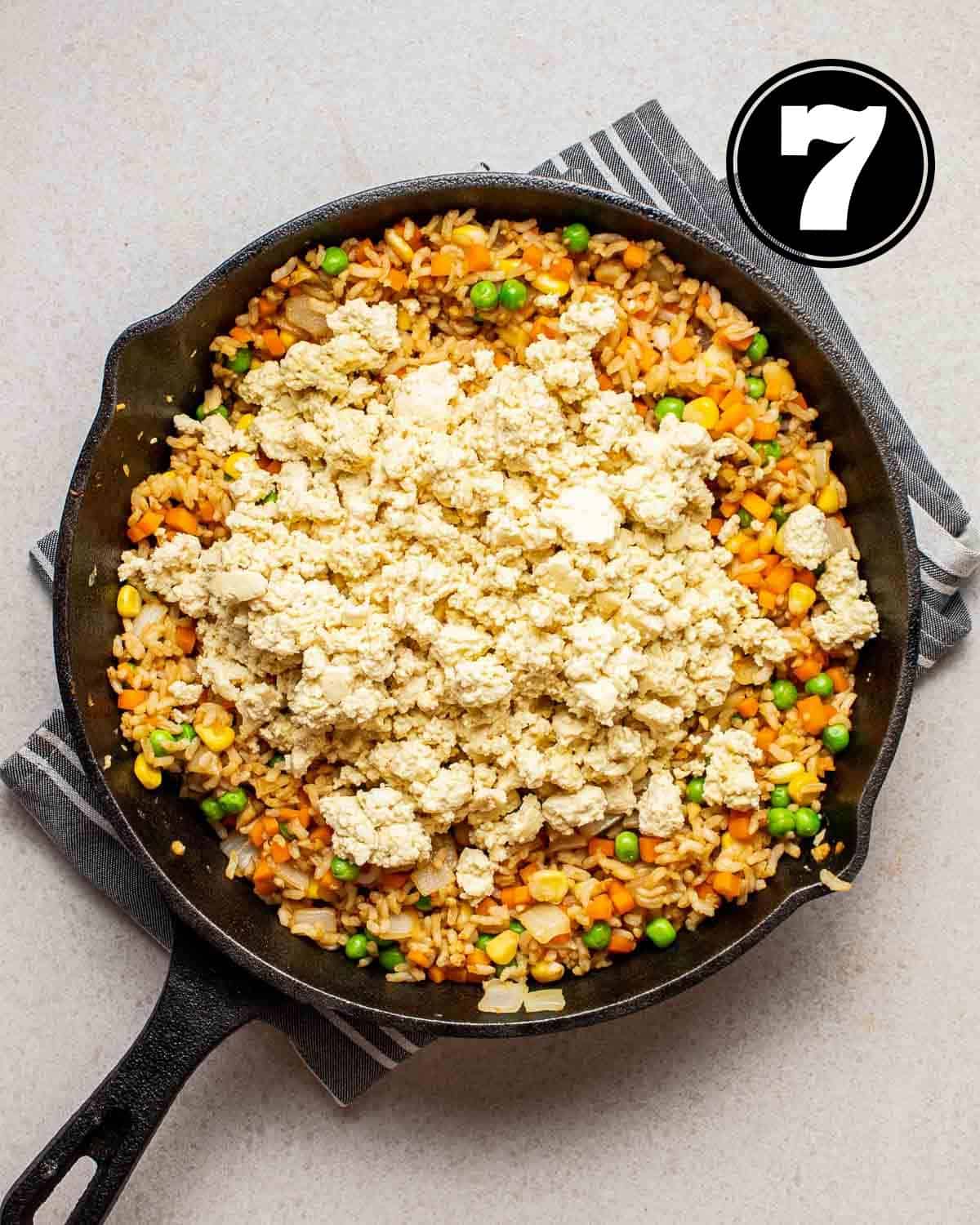 Adding tofu scramble to fried rice.