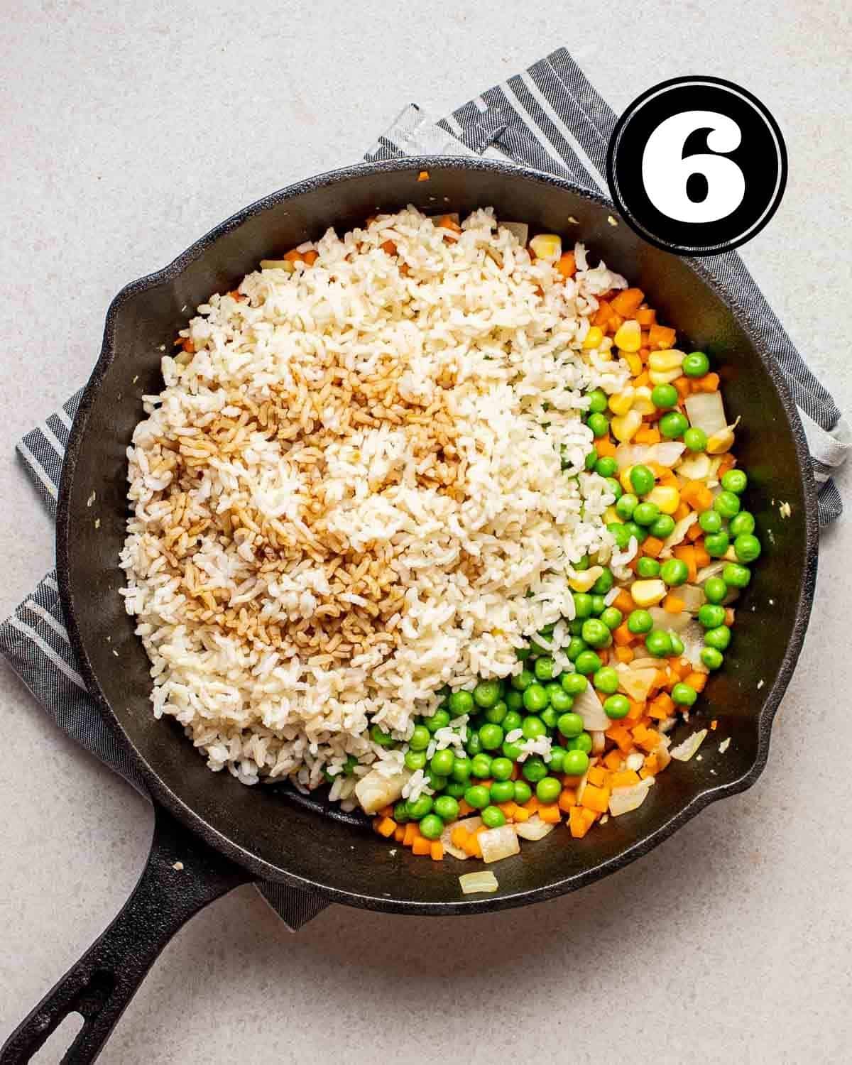 Rice, vegetables, and seasonings in a pan.