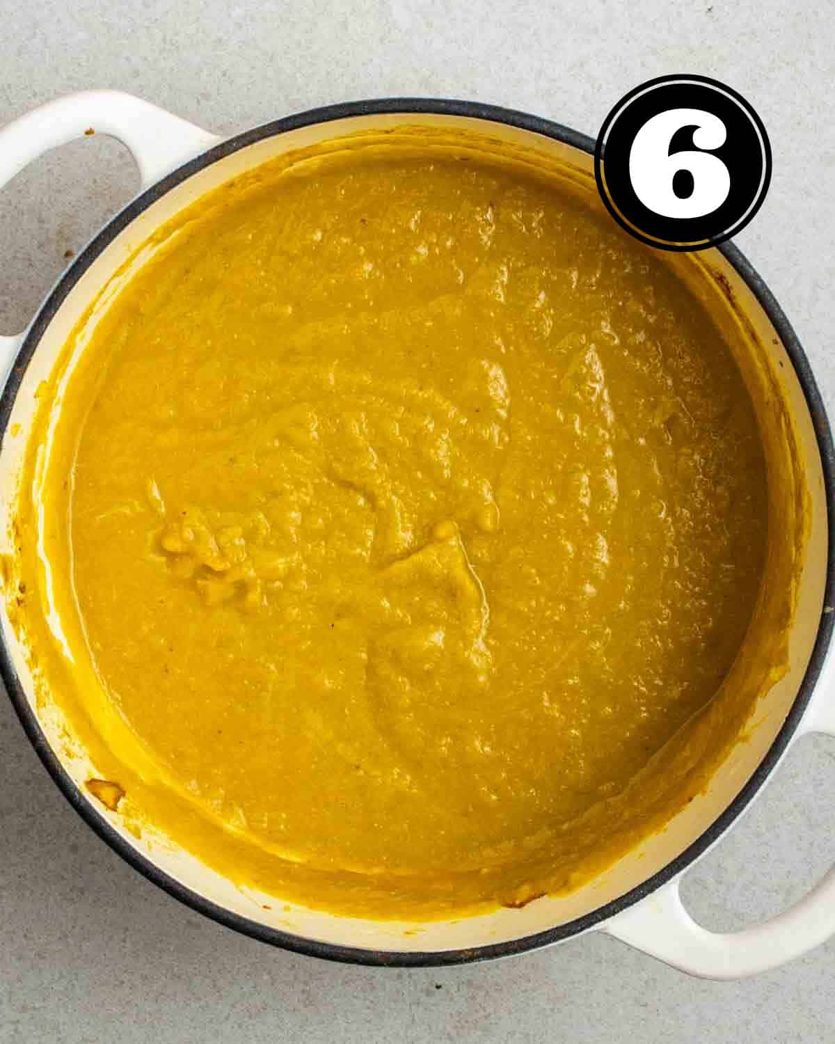 A pot of blended carrot lentil soup.