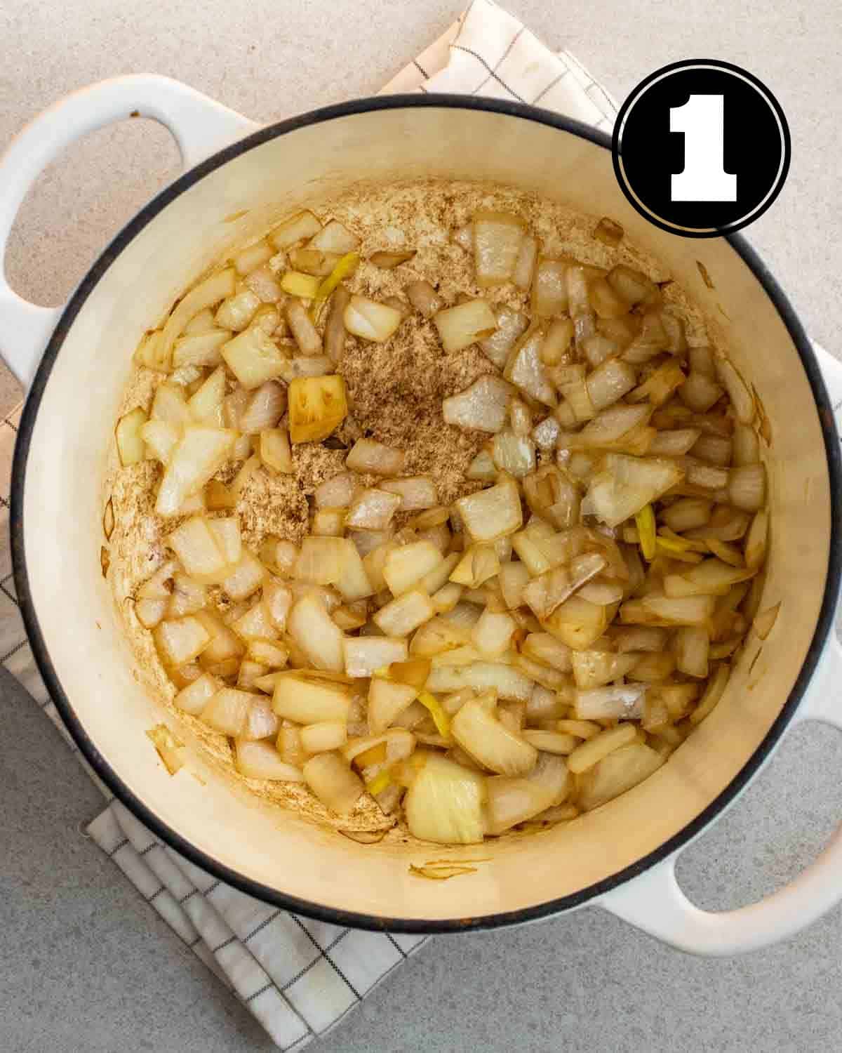 Cooked onion in a white Dutch oven.