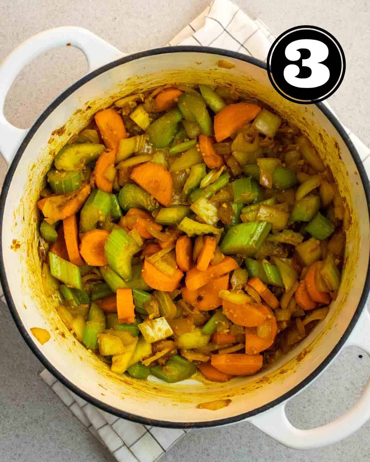 Cooked carrot, celery, and onion in a Dutch oven.