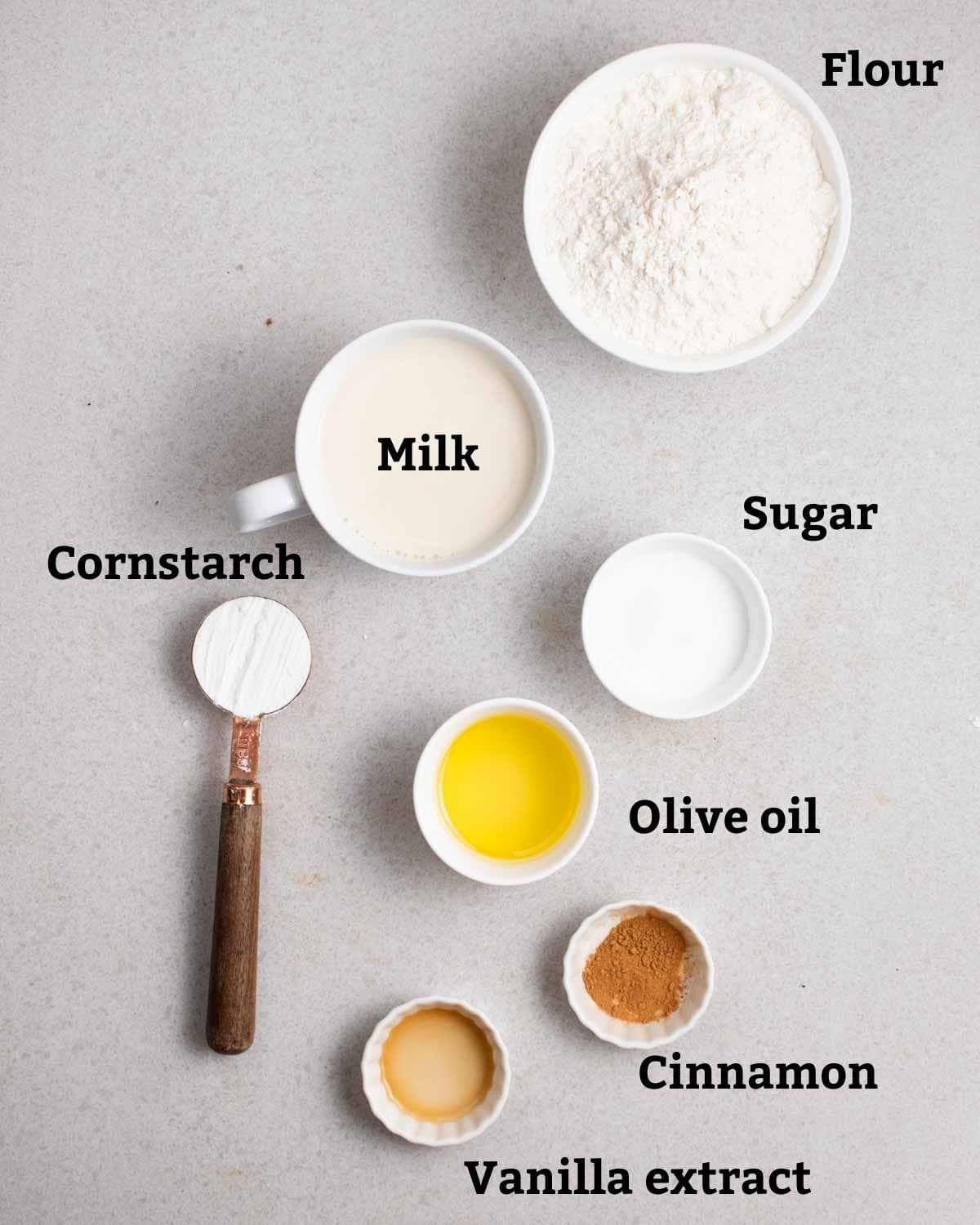Ingredients needed like flour, milk, sugar, cornstarch, olive oil, cinnamon, and vanilla extract.