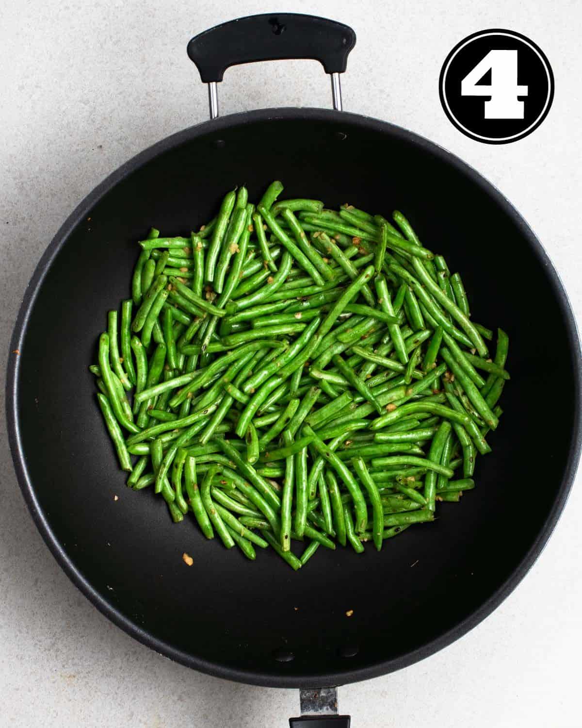 Cooked green beans in a wok.