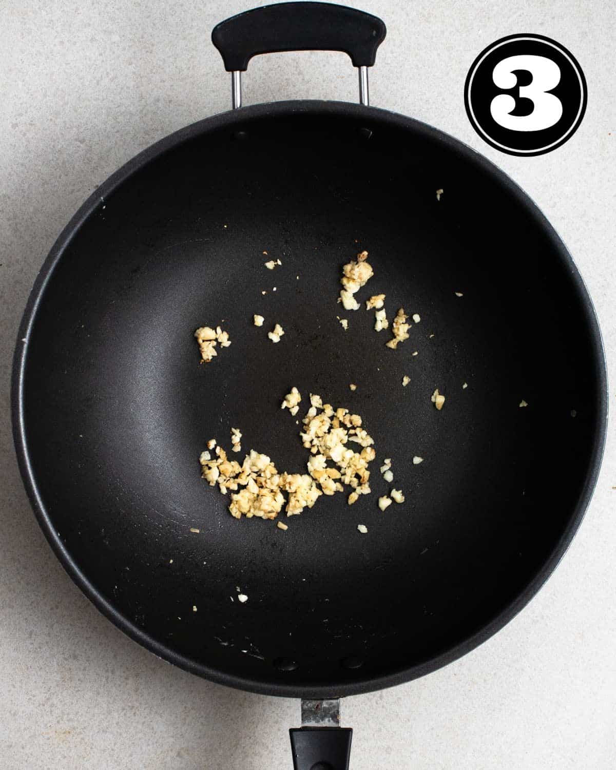 Cooked garlic and ginger in a wok.