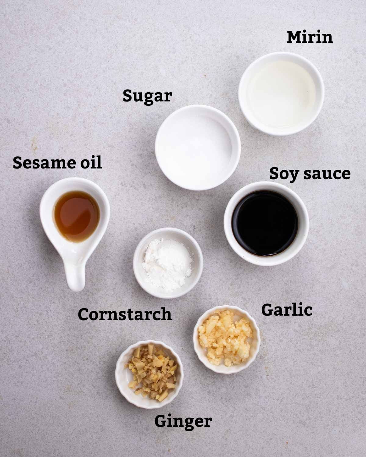 Ingredients needed for sauce like ginger, garlic, mirin, sugar, soy sauce, and sesame oil.