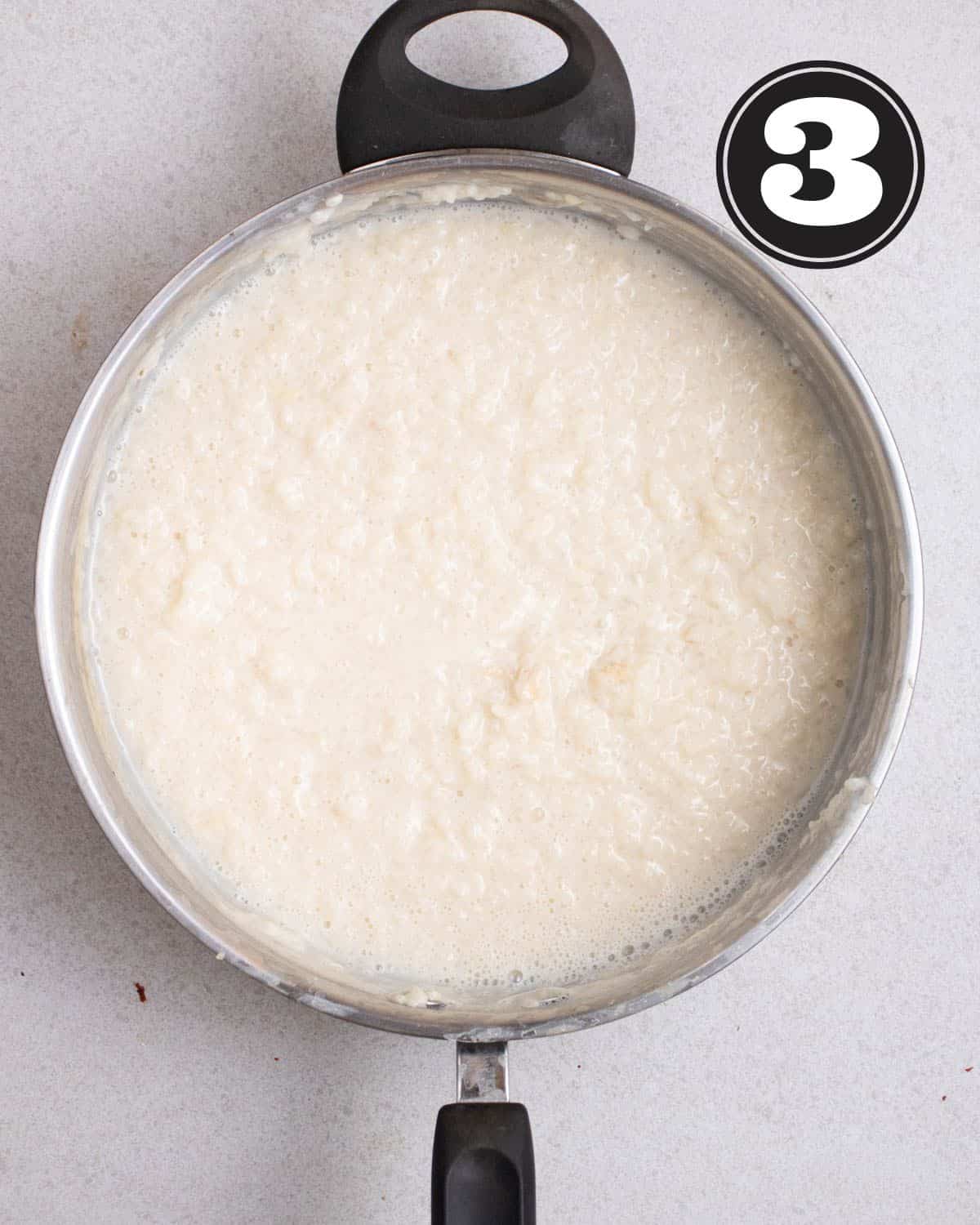 A pan of cooked rice pudding in a aluminum saucepan.