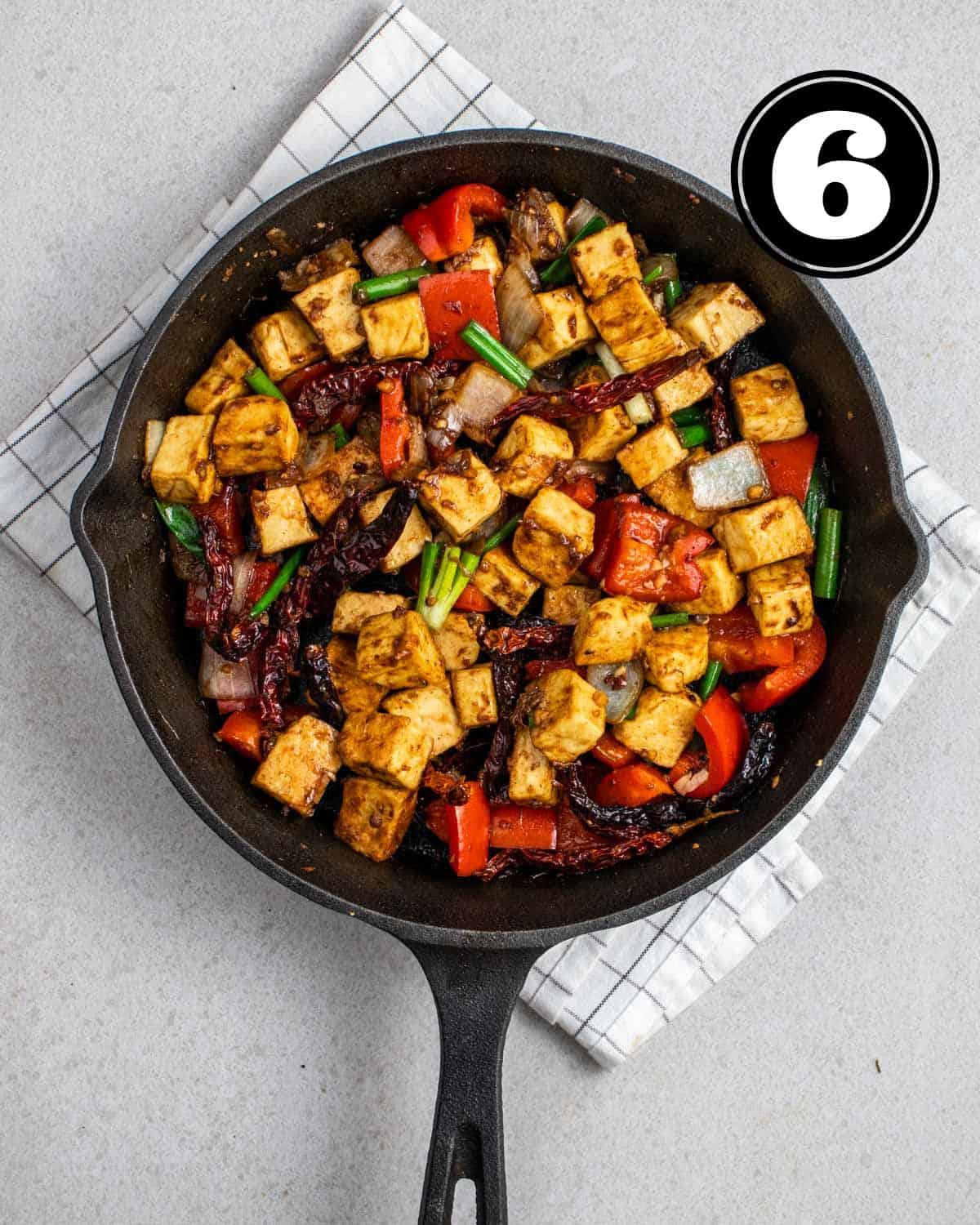 Cooked szechuan tofu in a cast iron skillet.