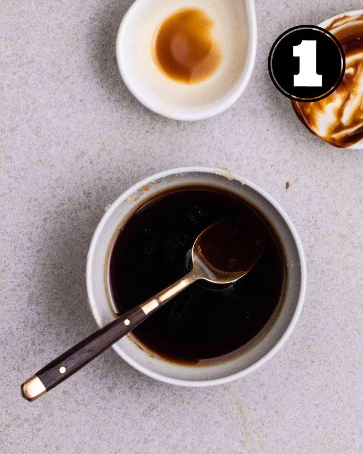 Stir-fry sauce in a small bowl with a teaspoon beside.