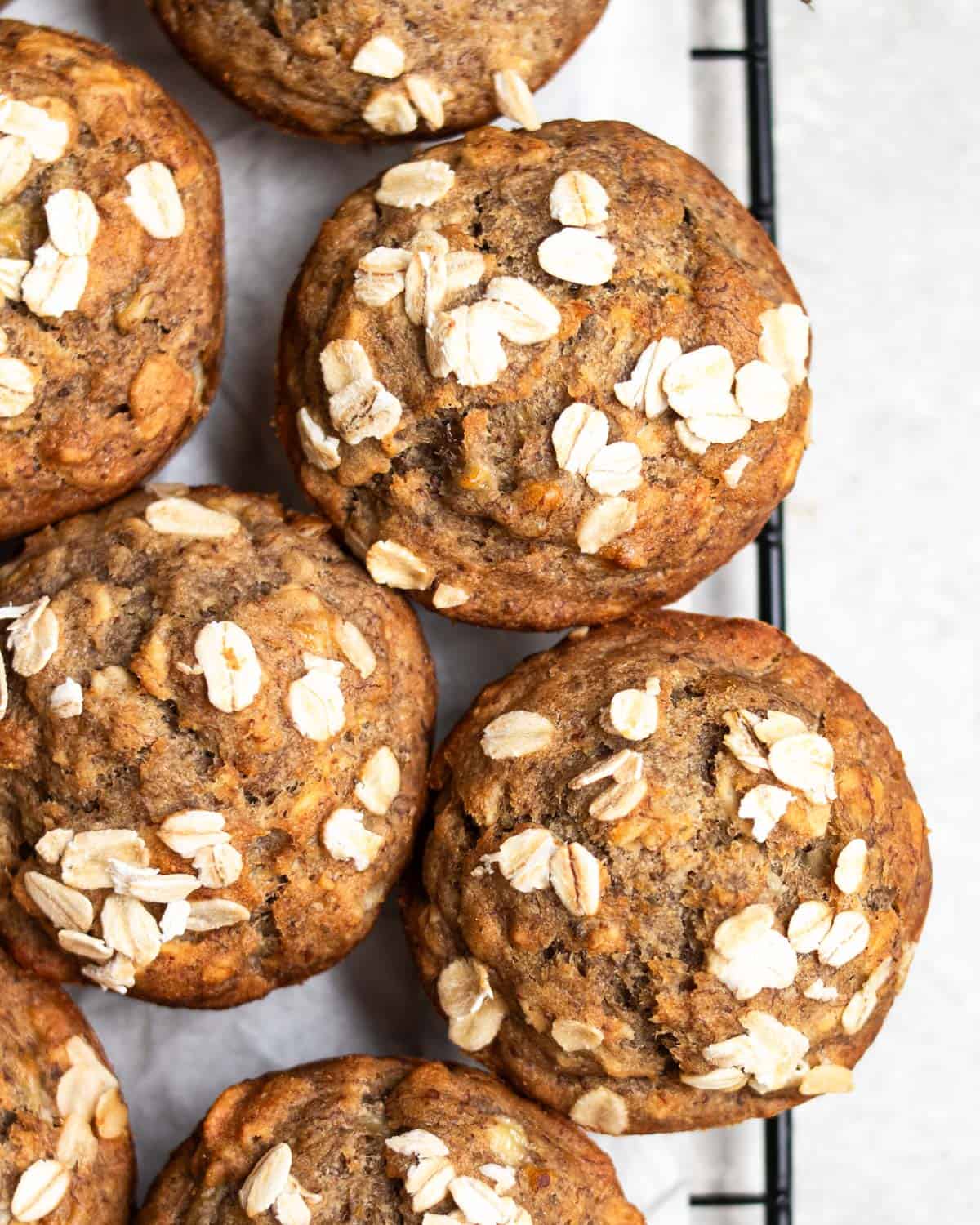 Muffins arranged on a baking tray layered with parchement paper.