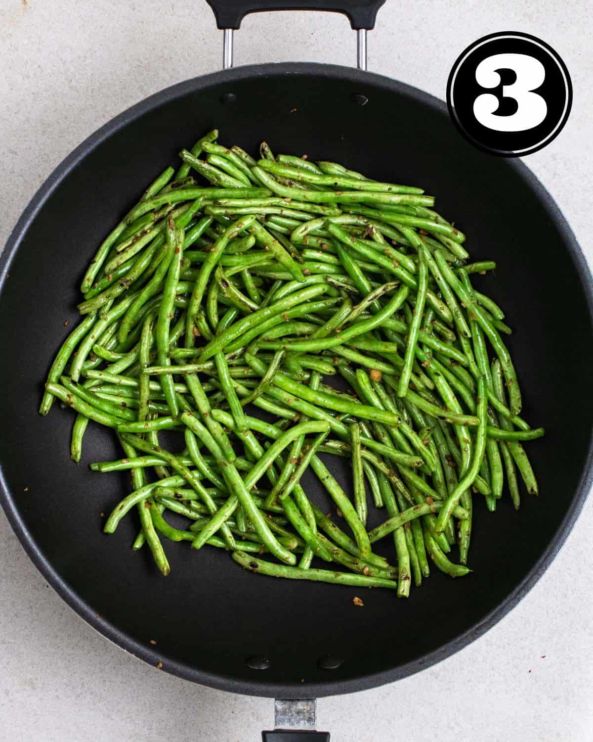 Cooked green beans in a wok.